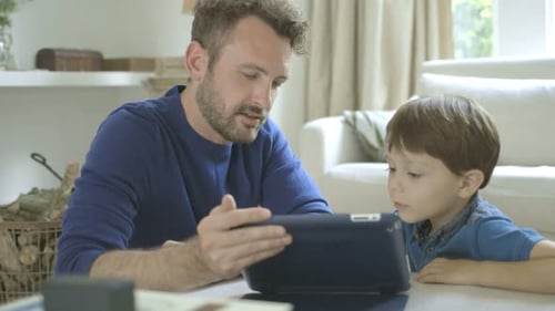 Father and Son Using a Tablet at Home