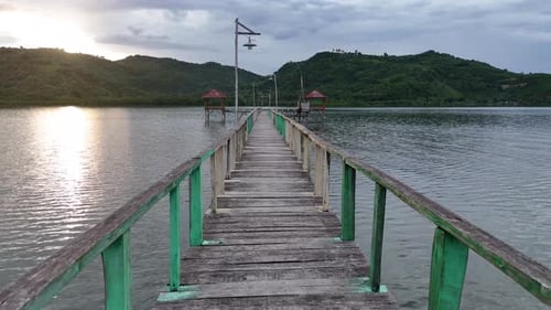 The bridge is made of wood that connects the house in the middle of the sea to the mainland.
