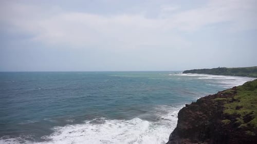 beautiful stretch of beach with blue sea water with big waves during the day