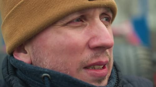 Focused Man in Brown Beanie and Black Jacket Looking Into the Distance