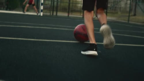 Person Dribbling Soccer Ball on Outdoor Sports Court