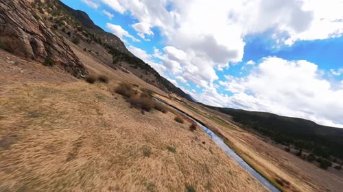 Slow FPV Drone Over Rocks and Winding River