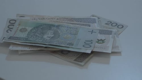 Throwing polish money on the table. Man's hand stacking different zloty banknotes in slow motion at