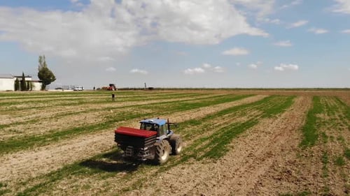 Tractor Spreading Fertilizer on Farm Field, Aerial View