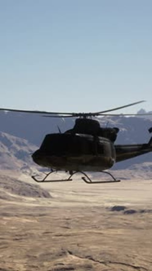 A Helicopter Flying Over a Desert Landscape with Mountains in the Background