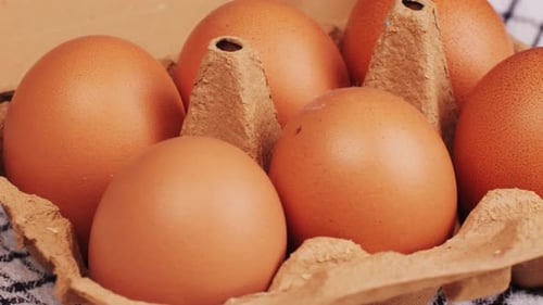 Fresh Chicken Eggs and Dried Straw on Black Wooden Table Closeup