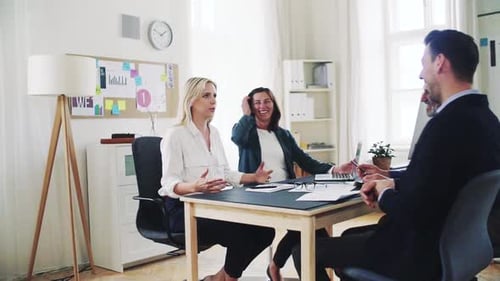 Diverse business team collaborating on laptop in modern office space