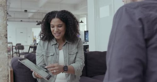Woman Explains Data on Tablet in Modern Office