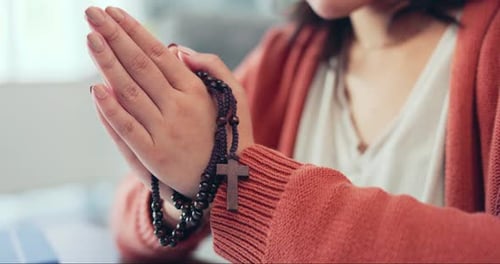 Woman Praying With Rosary Beads Indoors