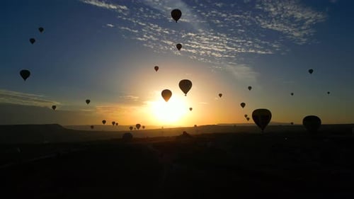 Hot Air Balloons at Sunrise Over Mountain Landscape