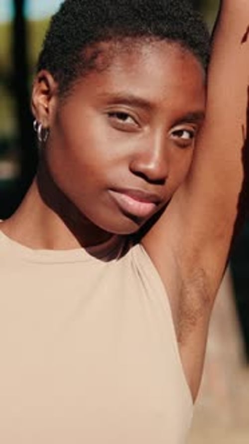 Close-up of attractive relaxed young woman standing near a tree in the park