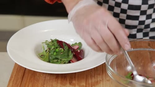 Gloved Hands Toss Healthy Salad in White Bowl