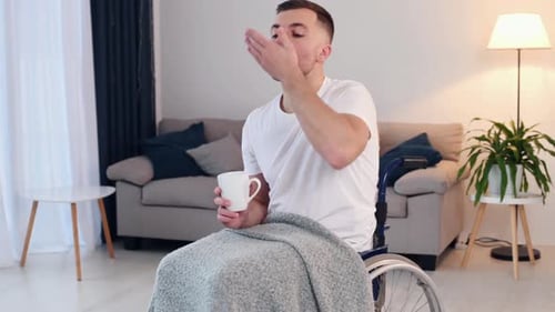 Taking pills. Meds for recovery. Disabled man is in the wheelchair at home