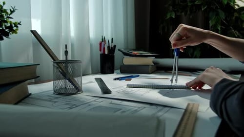 Architect Designing Blueprints with Tools on Desk