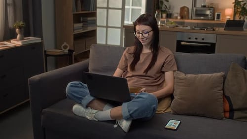 Woman on Couch Uses Laptop to Shop Online