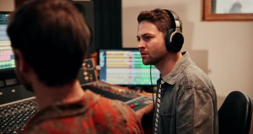Production, talking and producers with headphones for music in studio working on album or song
