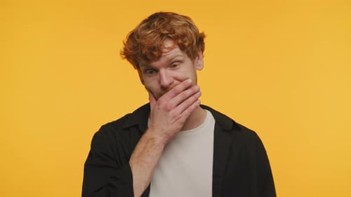 Young Man Covering Mouth With Hand, Smiling