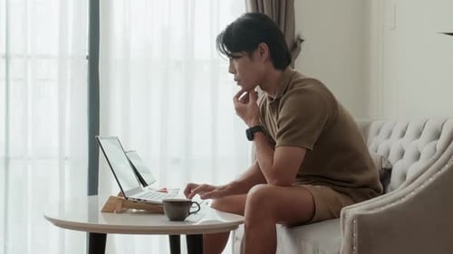 Young Adult Working on Laptop at Home