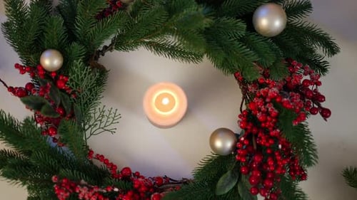 Top View Christmas Wreath on White Table with Burning Candle in the Middle
