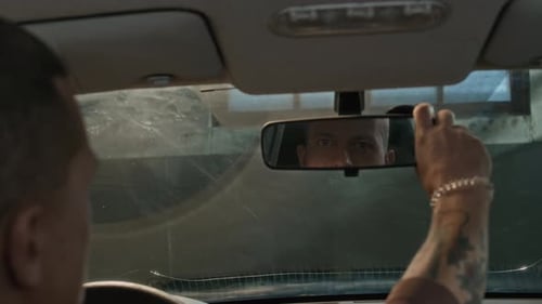 Guy Setting Rearview Mirror when Sitting Inside Automobile