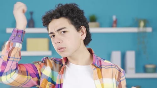 Young Man Adjusts Curly Hair Indoors