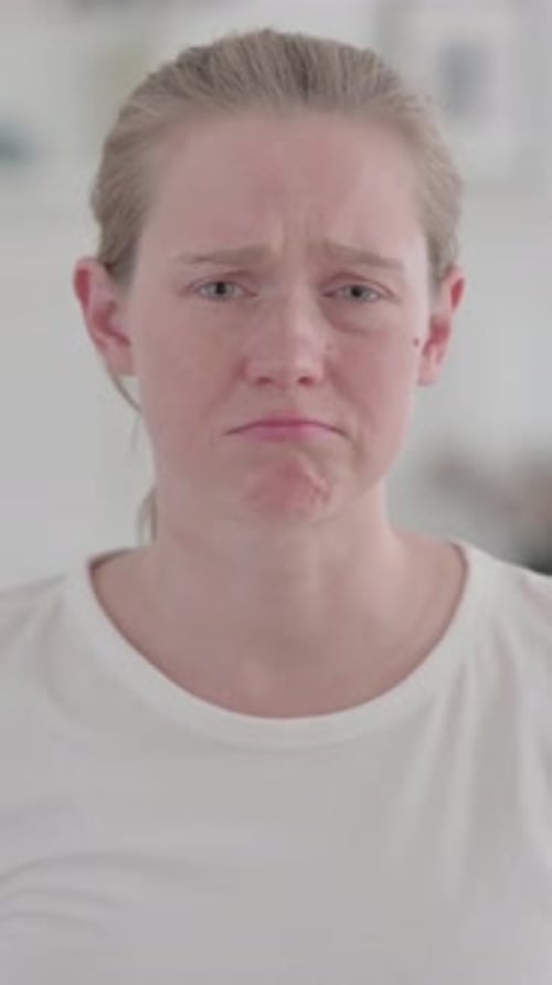 Porträt einer weinenden schönen jungen Frau, die sich zu Hause traurig fühlt, vertikales Video