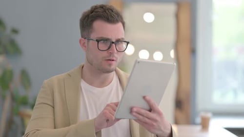 Man Reacts Negatively to Tablet in Modern Office
