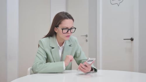 Woman Using Phone Looking Confused Indoors