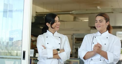 Deux chefs échangent des regards, sourient et posent à la porte du magasin avec un code QR, accueillant les invités