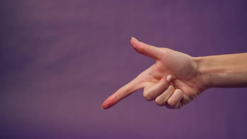 Schöne weibliche Hand auf isoliertem lilafarbenem Hintergrund, nackte Maniküre, zeigt Unzufriedenheit
