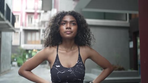 Young Black woman is exercising in city.