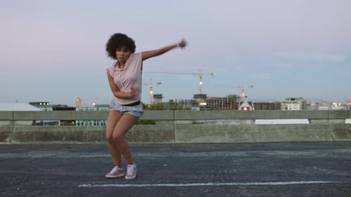 Trendy female dancing practicing choreography outside in a street