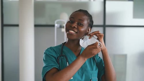 Female Doctor Removing Mask and Smiling Confidently