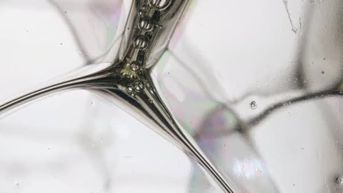 Foto macro de bolhas de sabão transparentes com pequenas bolhas fluindo no meio.
