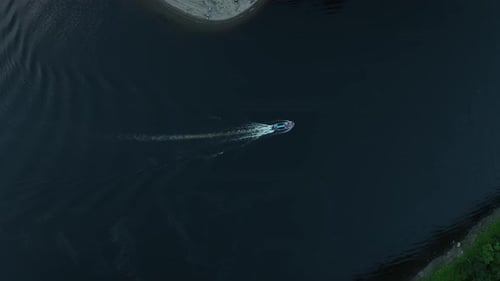 Motorboat Cruising In The River Leaving Wake In The Calm Waters. - aerial shot