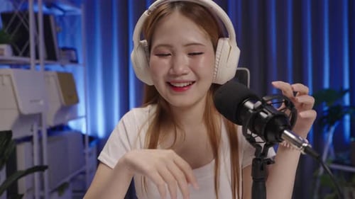 Podcast host listening to viewer's question during live show, medium close up angle