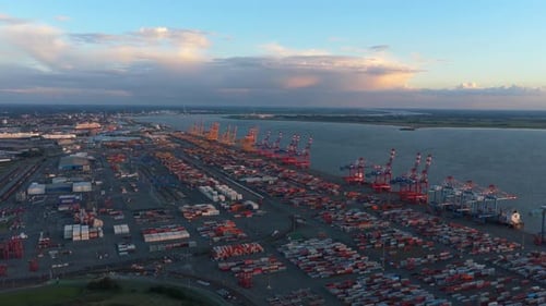 Bustling Industrial Container Port Glowing Under The Vibrant Night Sky