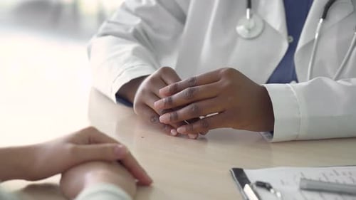 Doctor Giving Consultation and Comforting Patient Holding Hands