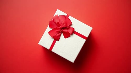 Top View on Gift Wrapped in Striped Gift Paper Decorated with Ribbon on Red