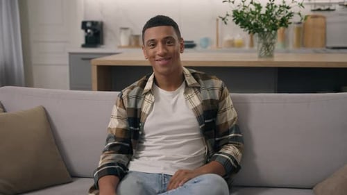 Young Man Smiling on Sofa in Modern Home