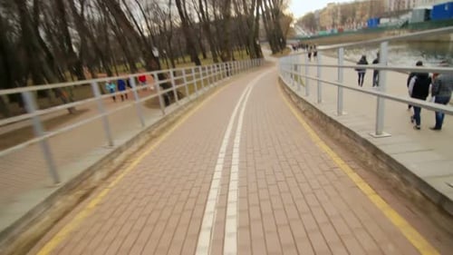 Cycling On Bicycle Path Along Embankment In City Park. Point Of View Bike Rider Speed Cycling. Sp...