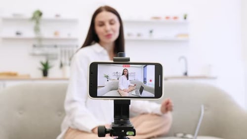 Anspruchsvoller Tutor nutzt modernes Smartphone mit Stativ für Online-Training