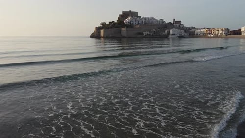 Aerial approach of the Castle and village from the beach and sea