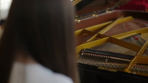 Closeup Rear View From Shoulder of Unrecognizable Female Pianist Sensually Playing on Grand Piano