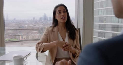 Two Business People Meeting in Boardroom Office with Skyline view