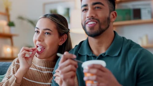 Couple Eating Snacks and Relaxing on Couch