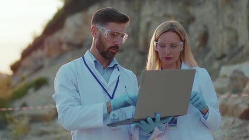 Researchers Analyzing Soil Sample at Sunset