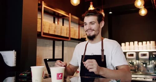 Smiling Barista Serving Coffee and Taking Payment