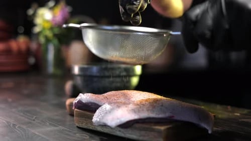 Male Chef Hands Sprinkling Seasonings Herbs to Fresh Meat Piece Cooking Food at Restaurant Kitchen