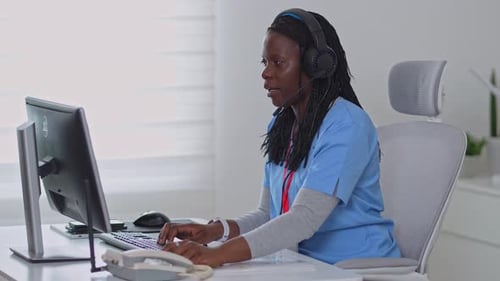 Medical Professional Typing at Computer in Office Setting
